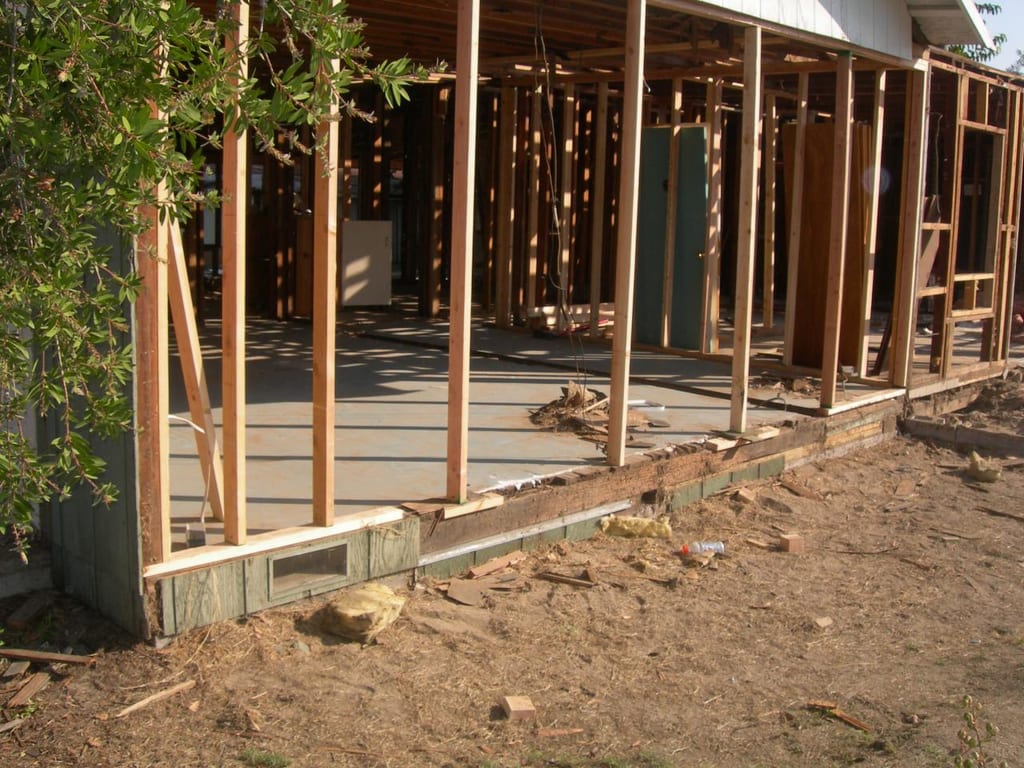 Garcia whole-house strip, foundation lift, and remodel: House lifted on jacks to remove failing footings and pour new foundation