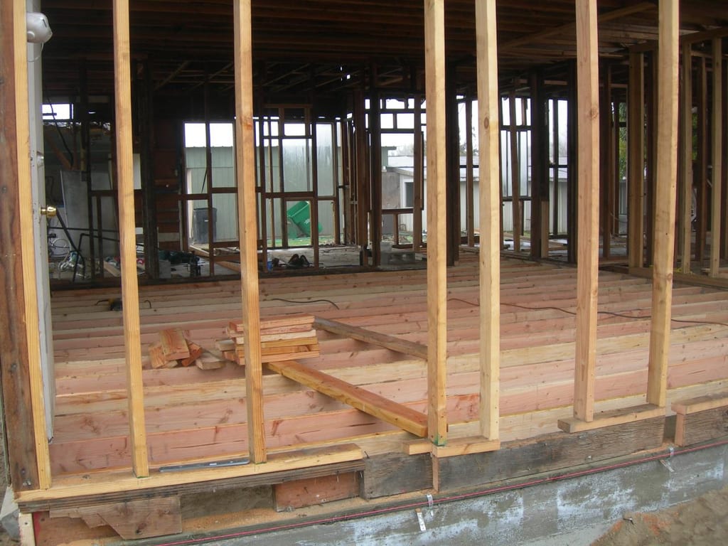 Garcia whole-house strip, foundation lift, and remodel: New floor joists and subfloor framing installed across the interior rooms