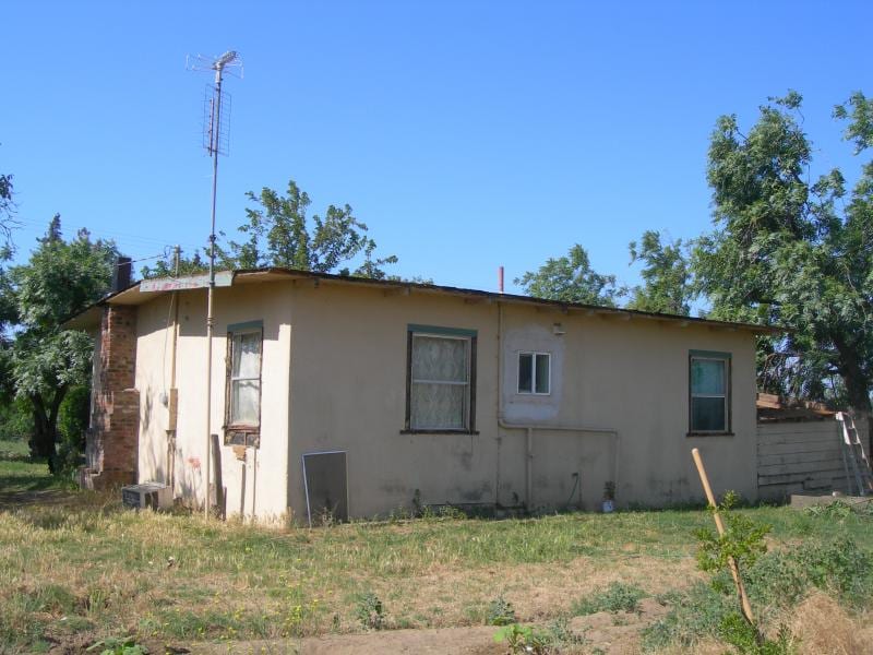 Magneson foundation lift and exterior remodel: Siding stripped to reveal dry-rot framing damage and failing foundation