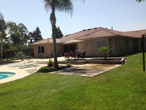 Covered stone outdoor kitchen: Concrete block masonry construction for island base and utility runs